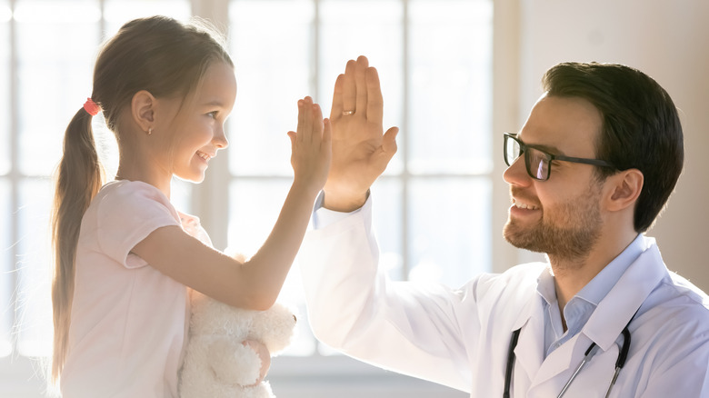happy girl giving high five to doctor 