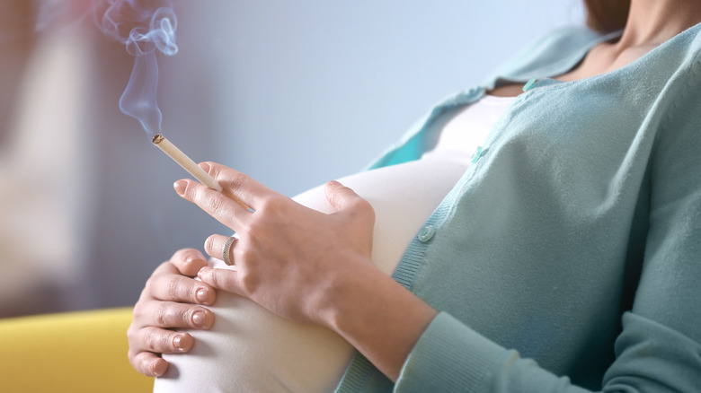 pregnant woman smoking at home   