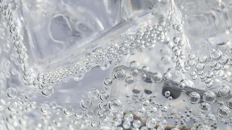 close up of soda water with ice and bubbles