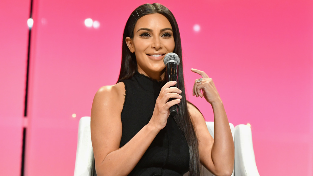 Kim Kardashian smiling with a microphone