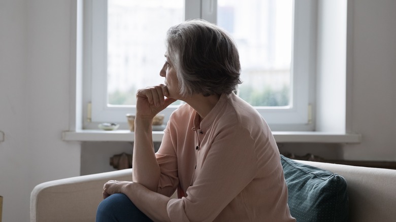 sad older woman sitting on sofa