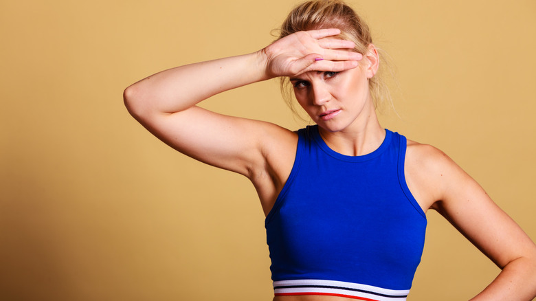 Woman wiping sweat from her brow