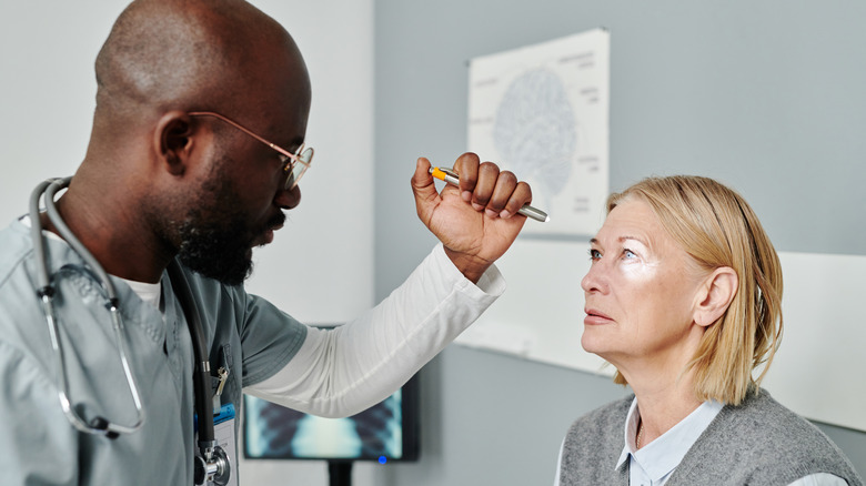 doctor checking woman's eye 