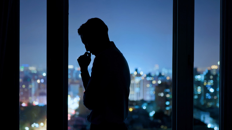 unhappy man looking out window