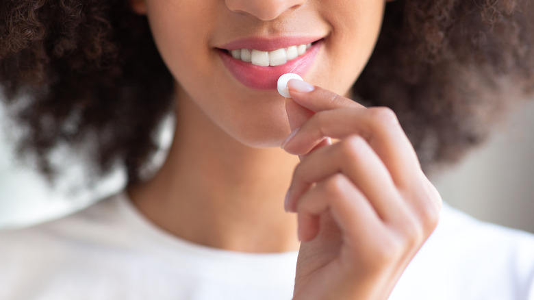 smiling woman taking pill