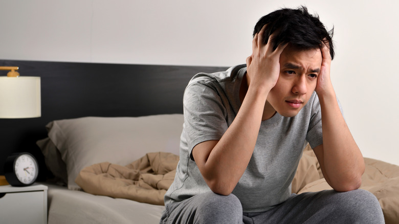 unhappy man sitting on bed