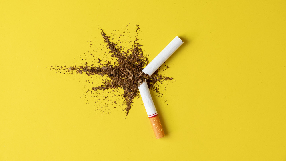 A broken cigarette against a yellow background