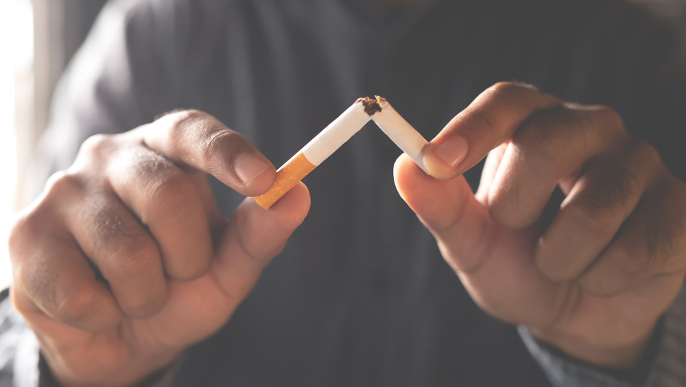 man snapping cigarette