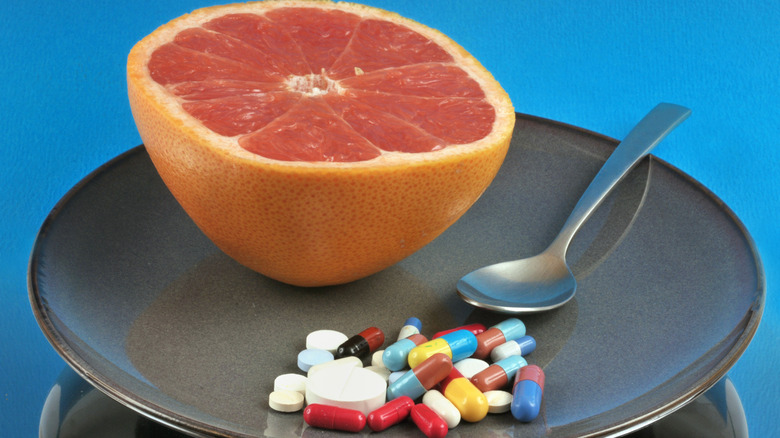 Grapefruit and pills on a plate