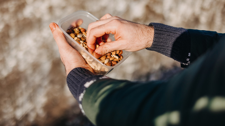 A man eating from a bowl of nuts