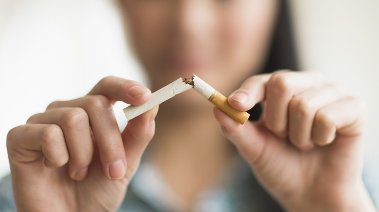 A woman's hands breaking a cigarette