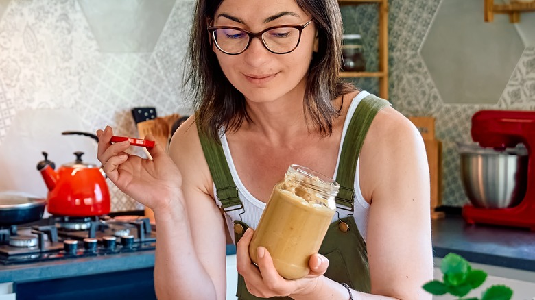 woman looking at peanut butter jar