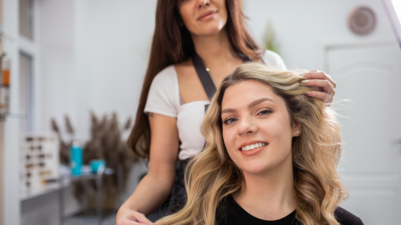 woman at hair stylist appointment evaluating face shape