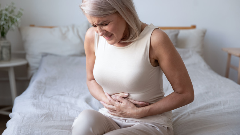 White mature woman holding stomach