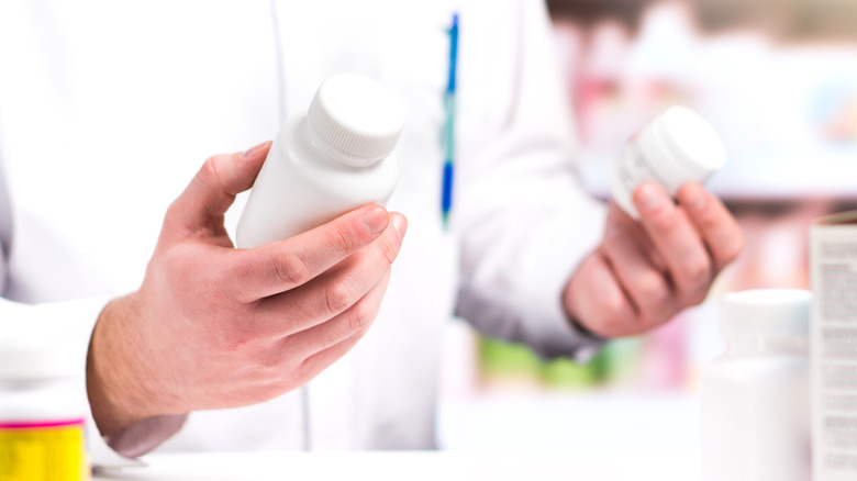 Pharmacist holding different bottles