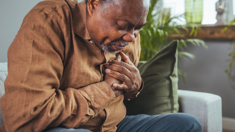 Elderly male clutching his chest