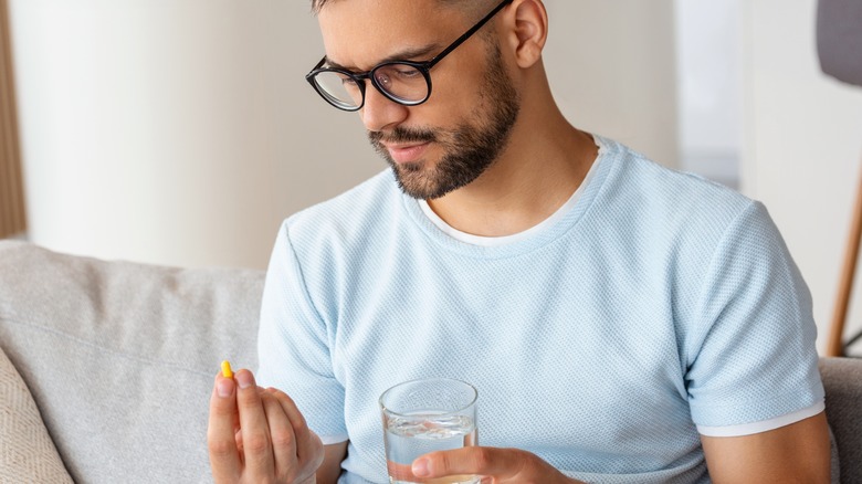 Man looking at a pill