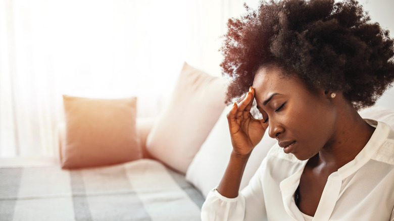 A woman touching her head in pain