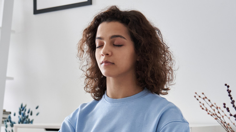 young woman meditating with closed eyes