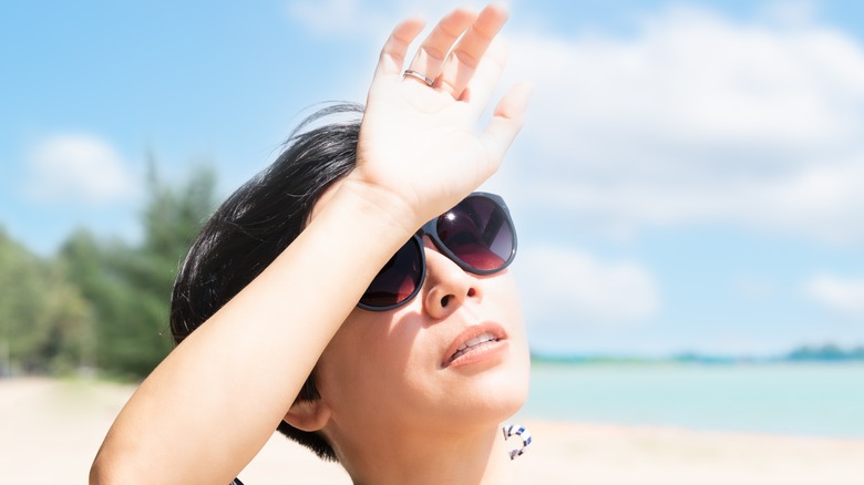 woman blocking sunlight with hand