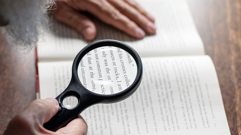 person reading with magnifying glass