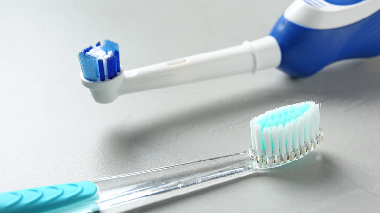 Electric and manual toothbrushes on white background