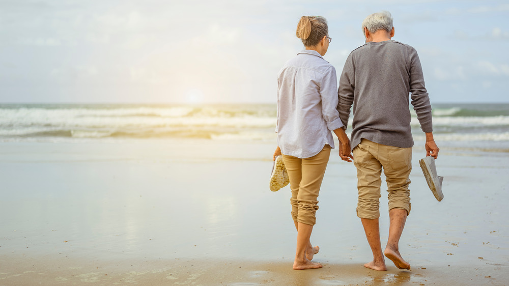 older couple walking on beach