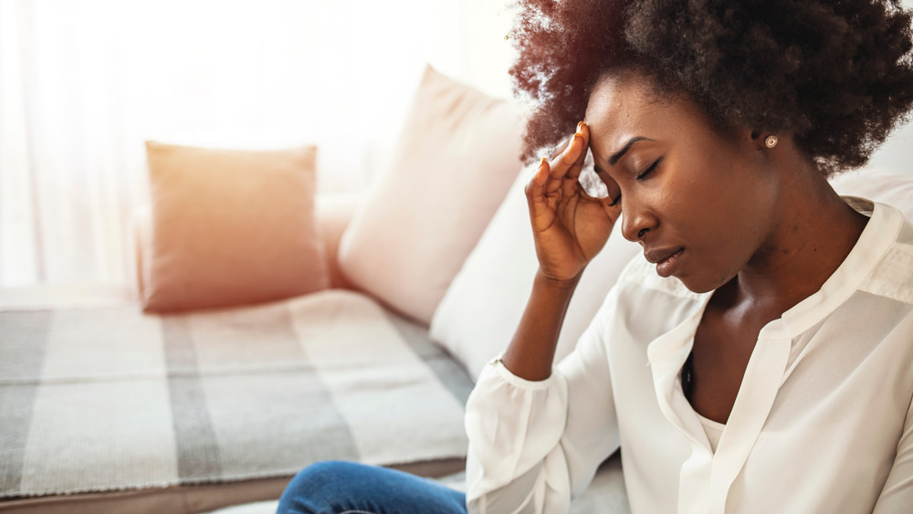 woman holding head from headache