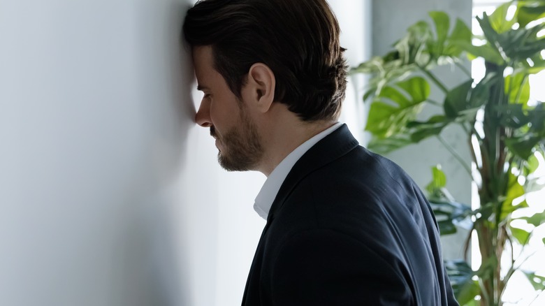 stressed businessman banging head on wall