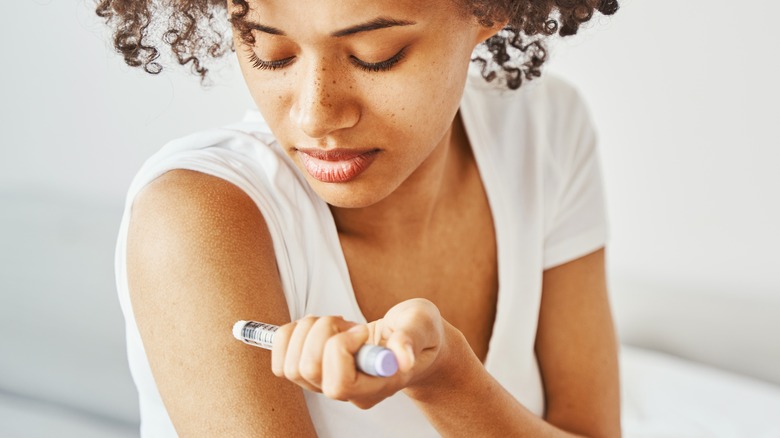 woman with diabetes injecting insulin