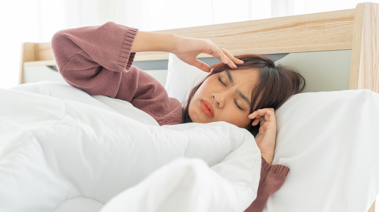 sick woman in bed with headache