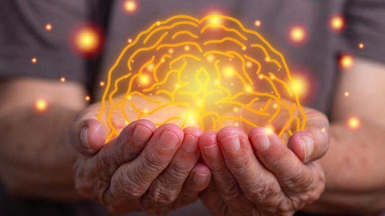 man holding image of illuminated brain