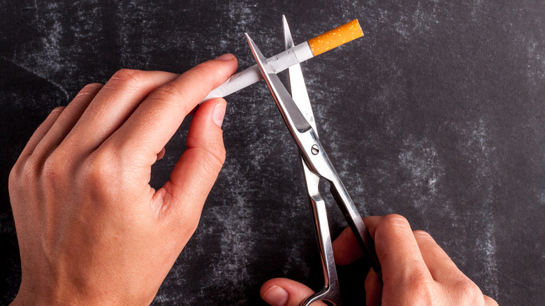 cutting cigarette in half with scissors