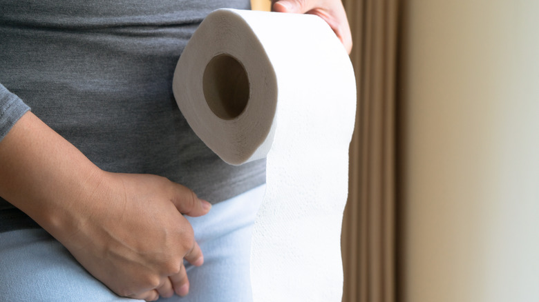 Hands holding roll of toilet paper