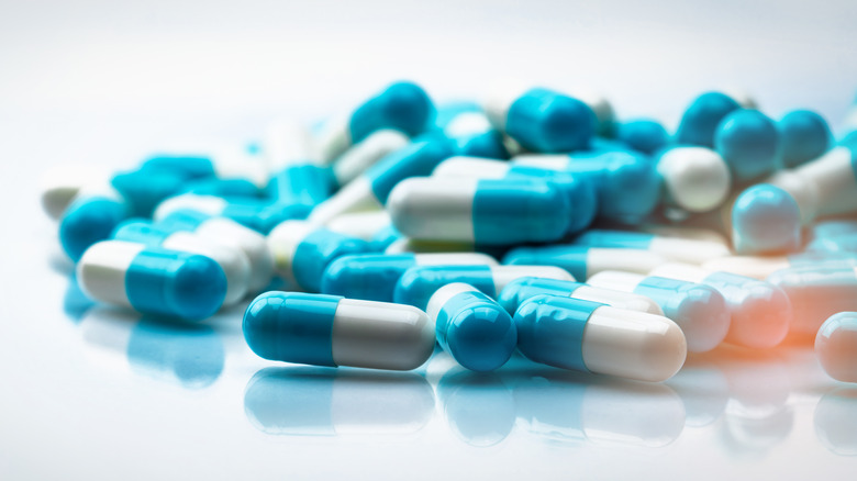 Selective focus on blue and white capsules pill on white background. 