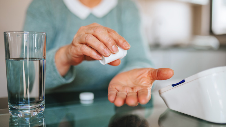 Woman about to take blood pressure medication