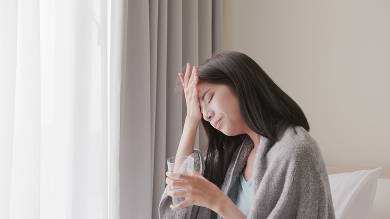 Sick woman holding a glass of water