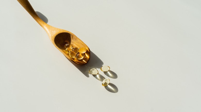 Wooden spoon with vitamin capsules