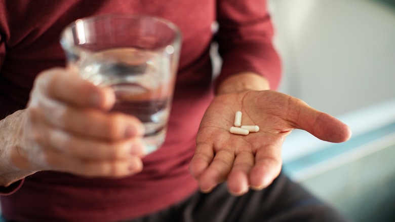 man's hand holding medication