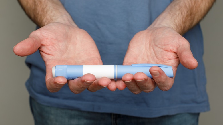 man holding semaglutide pen