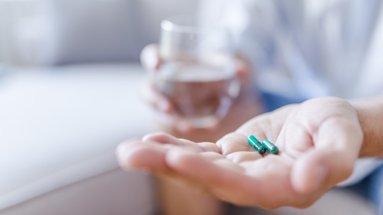 Man pouring out medication from bottle