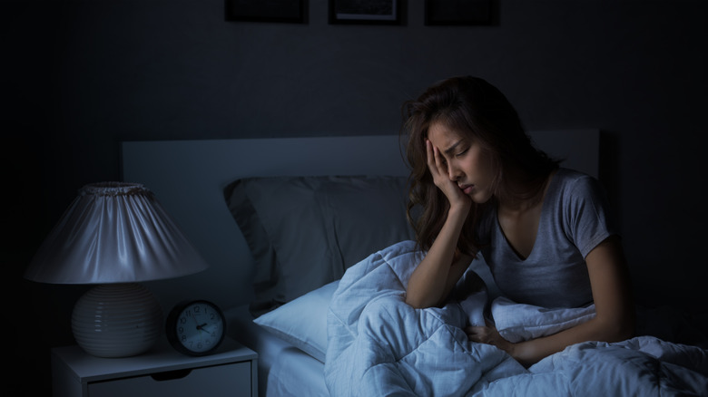 Distressed woman sitting in bed