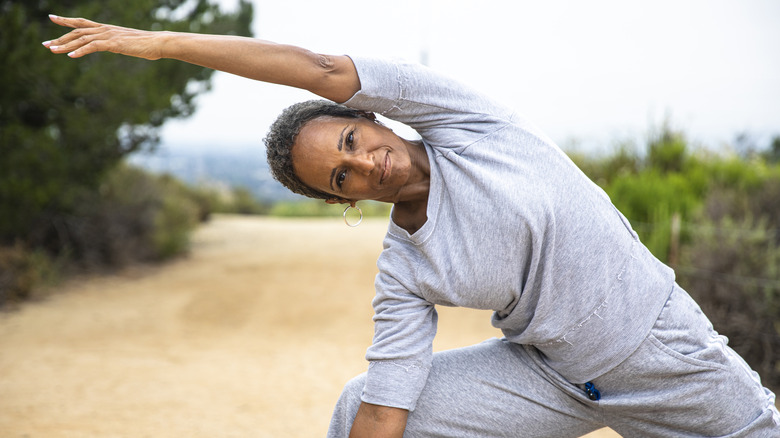 happy midlife woman stretching outdoors