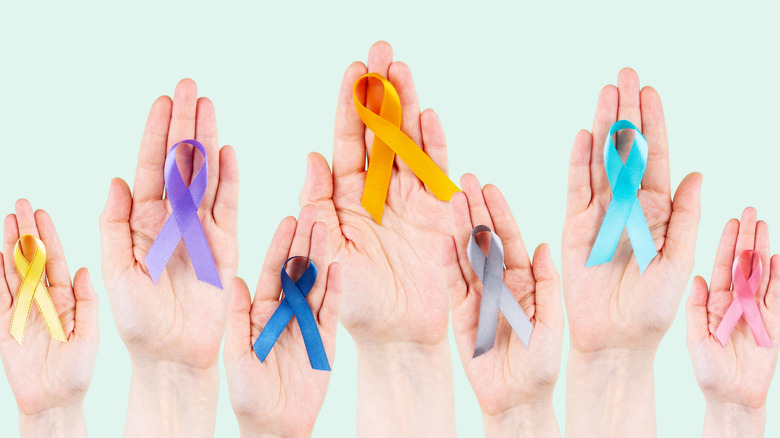 Hands holding different colored ribbons