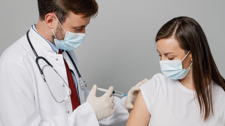 Doctor giving vaccine to patient