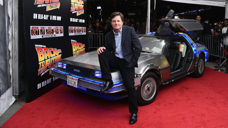 Michael J. Fox poses on hood of the Delorean from "Back to the Future"