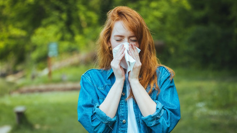 Woman with a runny nose standing outside