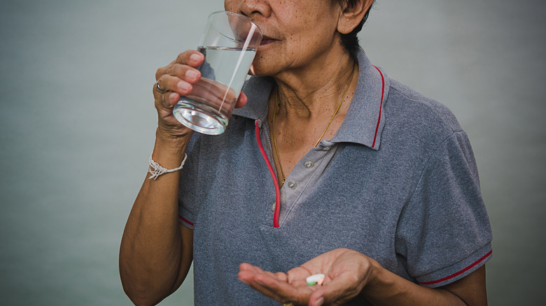 older woman taking pills