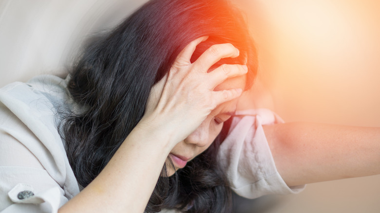 Woman suffering migraine with an aura