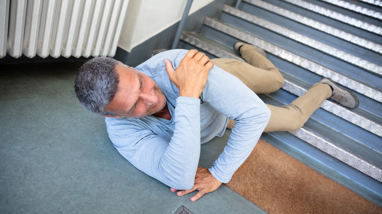 man holding shoulder after falling 